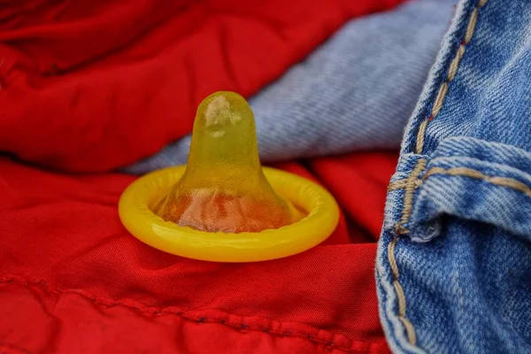 Yellow Condom Rests Pocket Red Trousers — Stock Photo, Image