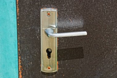 kahverengi bir demir kapı üzerinde bir gri metal kapı kolu