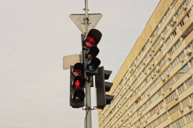 gökyüzü ne ve evin duvarına karşı sokakta bir kutup üzerinde trafik ışıkları
