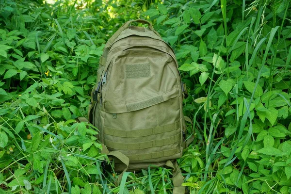 Jeden Duży Plecak Stoi Zielonej Trawie Liści Roślinności Przyrodzie — Zdjęcie stockowe