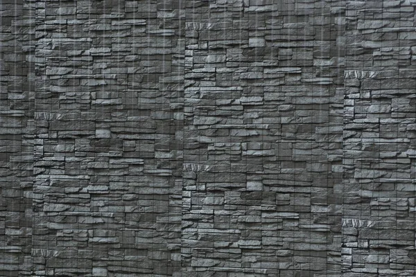 gray dark texture of stone tiles in the wall of the fence