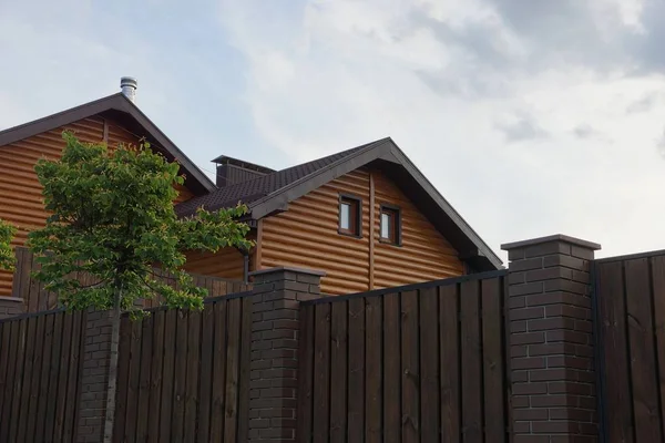 私人木制棕色房子的阁楼 栅栏后面的窗户 — 图库照片