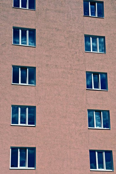 A row of windows on the brown wall of a multi-storey building