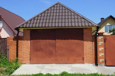 sokakta kiremitli çatı altında metal kapılar ile kahverengi bir garaj cephesi