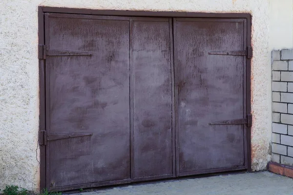 灰色のガレージの壁にある大きな茶色の金属製の門 — ストック写真
