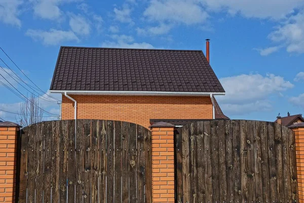 Privates Backsteinhaus Mit Ziegeldach Hinter Braunem Holzzaun — Stockfoto