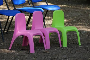 üç küçük plastik renkli sandalye parkta yere standı