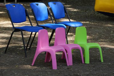 üç küçük plastik renkli sandalye yerde durmak 