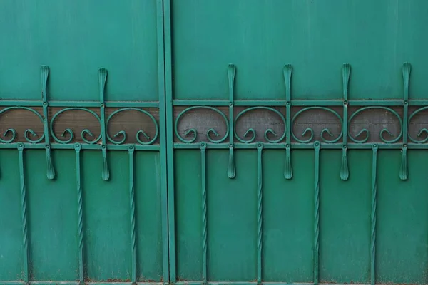 green metal texture of iron wall with forged pattern