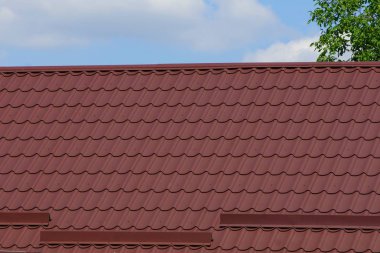 gökyüzü ve bulutlar karşı kahverengi kiremit altında bir çatı ile evin parçası