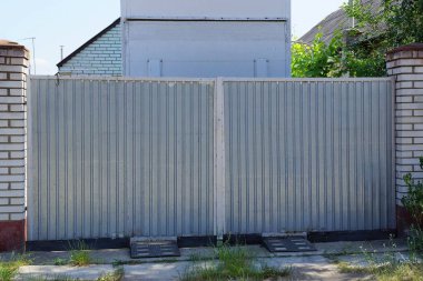 kırsal bir sokakta büyük bir gri metal kapı