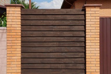 kırsal bir sokakta tuğla ve ahşap tahta yapılmış kahverengi çit parçası