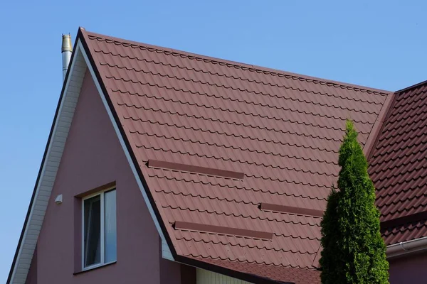 青空に対する窓のある民家の茶色のタイル張りの屋根 — ストック写真