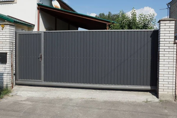 one big gray metal gate on a rural street