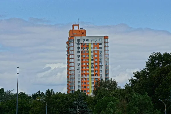 空と雲に対する緑の植生の大きな色の背の高い家 — ストック写真