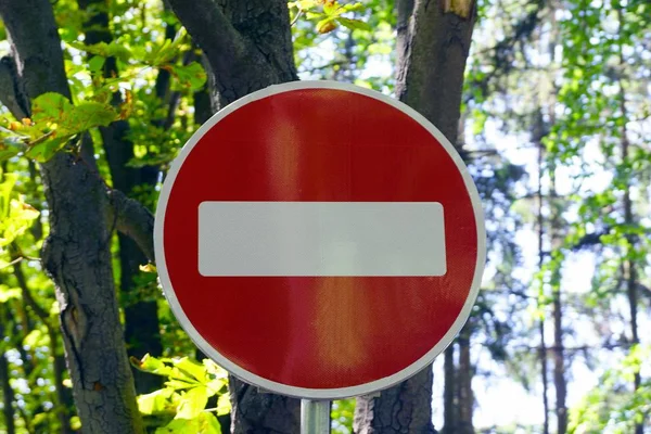 木々と緑の葉を背景に1丸い赤い道路標識 — ストック写真