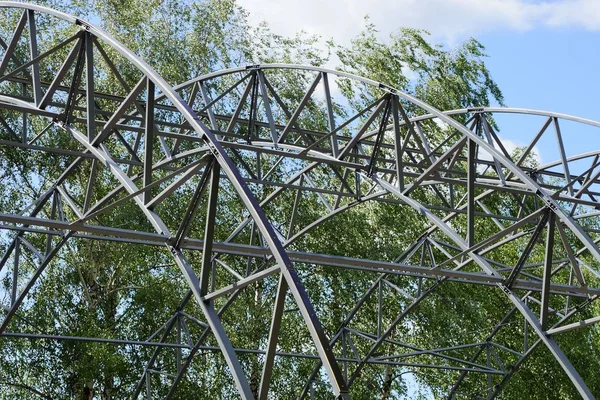 Parte Construção Metal Cinzento Contra Fundo Ramos Verdes Céu — Fotografia de Stock