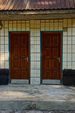 Apartmanın duvarında iki kapalı ahşap kapı