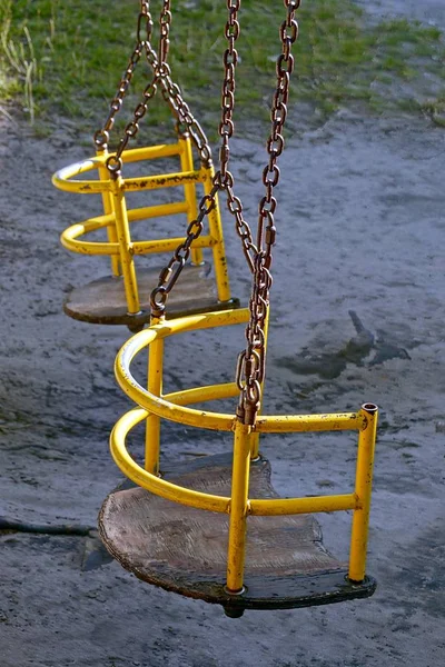 Iron swing with seats on the chain in the playground