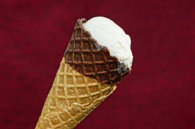 kırmızı bir arka plan üzerinde kahverengi bir waffle fincan bir beyaz dondurma