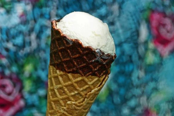 one white ice cream in a brown waffle cup on a colored background