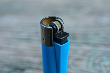  gri bir masa üzerinde mavi eski plastik çakmak duruyor