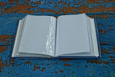 mavi bir sefil masada beyaz sayfaları ile bir açık plastik albüm