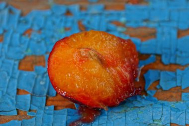 olgun erik bir kırmızı parça mavi bir masa üzerinde yatıyor