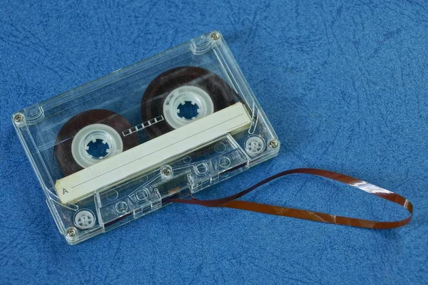 一个灰色的旧录音带躺在蓝色板上 — 图库照片
