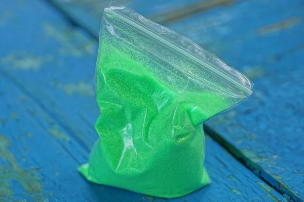Пластиковий Пакет Зеленим Піском Синьому Столі — стокове фото
