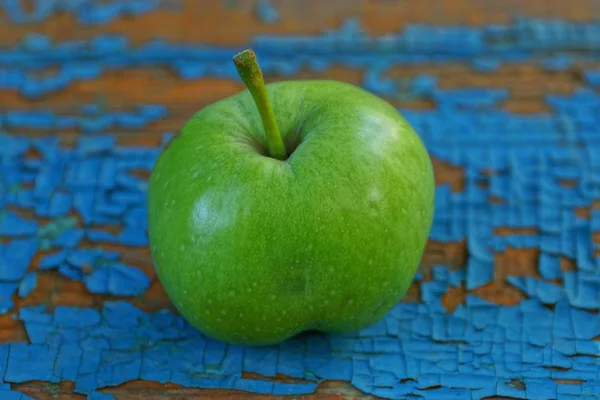 Ein Großer Grüner Apfel Liegt Auf Einem Blauen Kratzbrett — Stockfoto