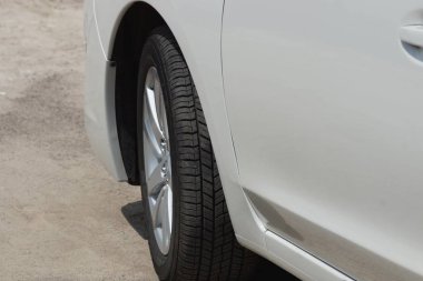 siyah tekerlekli gri bir binek otomobil asfalt yolda duruyor