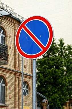 ağaçlar ve yeşil yaprakları bir arka planda bir yuvarlak kırmızı yol işareti