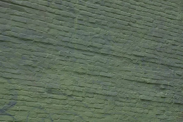 Green background of a brick wall on the facade of a residential building