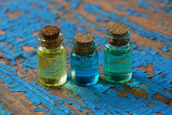 Kleine Glazen Flesjes Met Gekleurde Oliën Staan Een Versleten Blauwe — Stockfoto