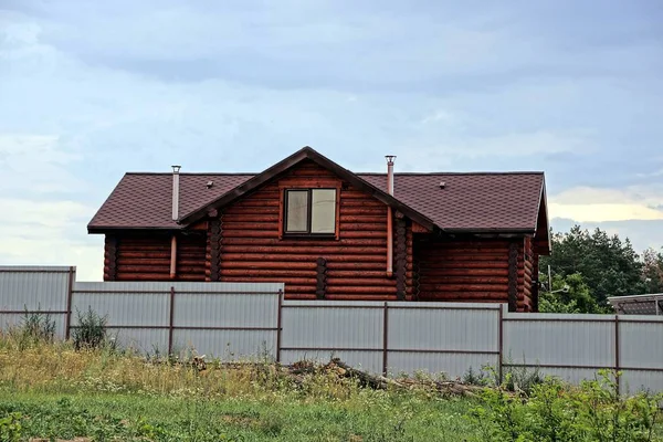 铁栅栏后面的棕色木屋 — 图库照片