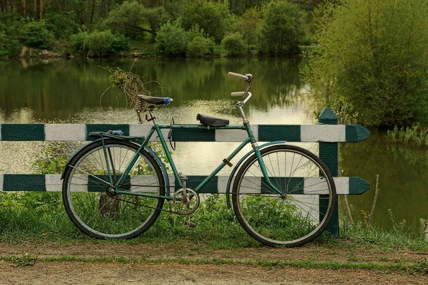 Una Bicicleta Vieja Está Pie Cerca Una Cerca Madera Paseo —  Fotos de Stock