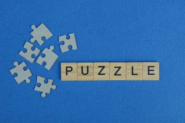 Viele Graue Papierpuzzles Und Ein Wort Aus Holzbuchstaben Auf Einem — Stockfoto