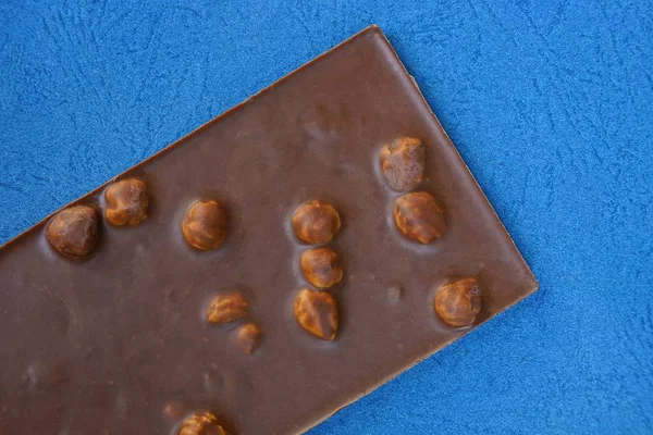 Big Brown Bar Chocolate Nuts Lies Blue Table — Stock Photo, Image