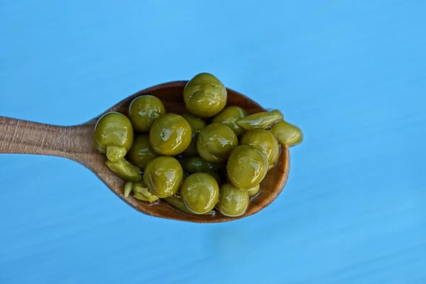 Green Peas Wooden Spoon Blue Background — Stock Photo, Image