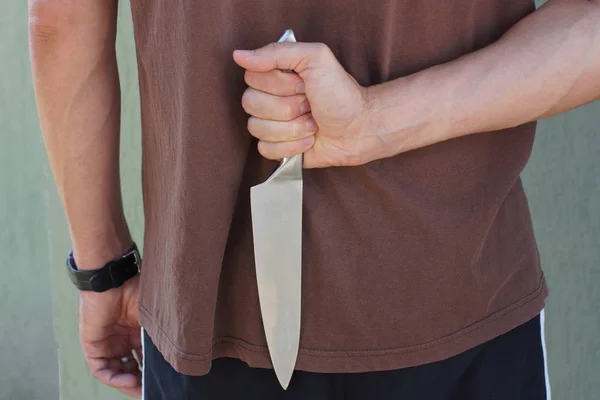 Мужчина Коричневой Одежде Держит Спиной Нож — стоковое фото
