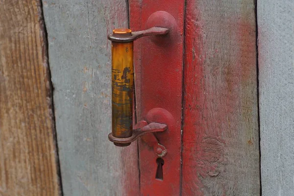 Gri Ahşap Kapı Panoları Üzerinde Eski Kırmızı Kapı Kolu — Stok fotoğraf