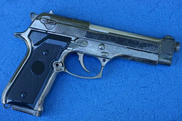 bir büyük gri hava tabancası mavi bir masa üzerinde yatıyor