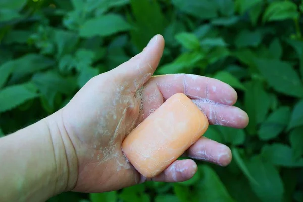 Sabão Rosa Torcido Mão Sobre Fundo Vegetação Verde — Fotografia de Stock