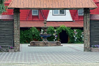 Açık bir kapının arkasındaki evin yakınındaki özel bir avluda Çeşme