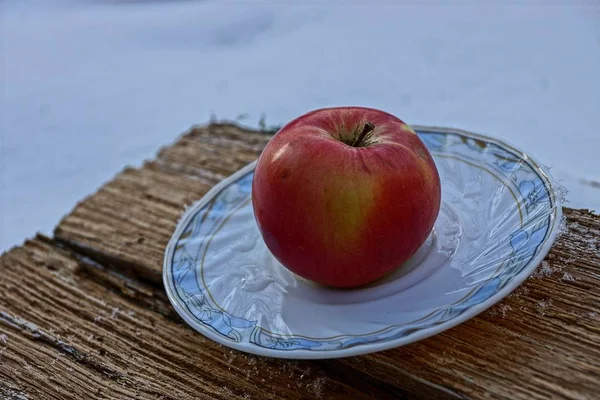 Roter Apfel Auf Weißem Teller Der Auf Einem Stück Holz — Stockfoto