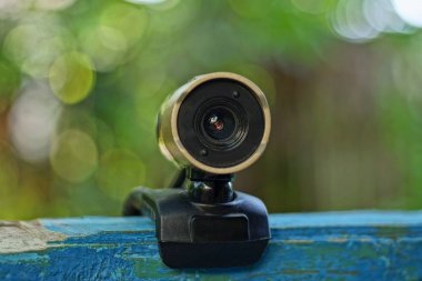 açık havada mavi bir tahta duvarda küçük kahverengi siyah web kamerası