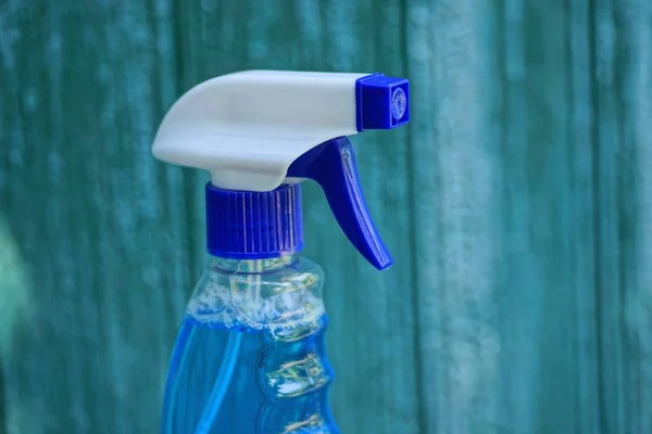 緑色の背景に液体ボトルのプラスチック青い白いスプレーボトル — ストック写真