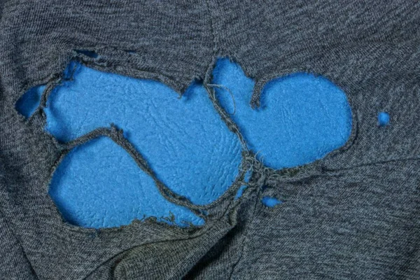 Τρύπα Παλιά Γκρι Ύφασμα Ρούχα Μπλε Φόντο — Φωτογραφία Αρχείου