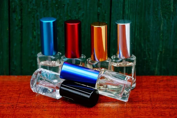Zestaw Małych Kolorowych Butelek Perfum Stole Pobliżu Ściany Drewniane — Zdjęcie stockowe